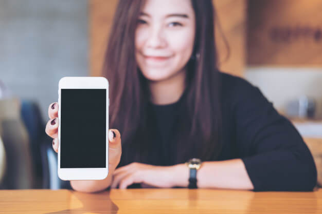 mulher segurando um celular IMEI imei-como-saber-o-seu