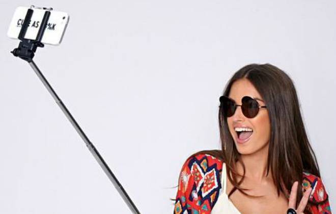 moça tirando selfie com o pau de selfie e smartphone com boa câmera
