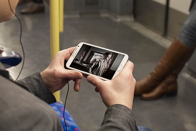 usuário de smartphone com tv digital no ônibus