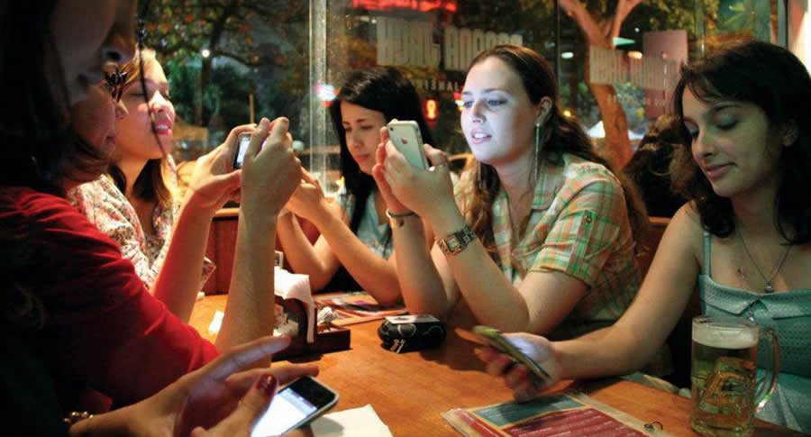 Pessoas no bar com o celular Pessoas no bar com o celular