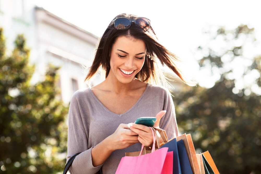 Mulher no celular fazendo compras Mulher no celular