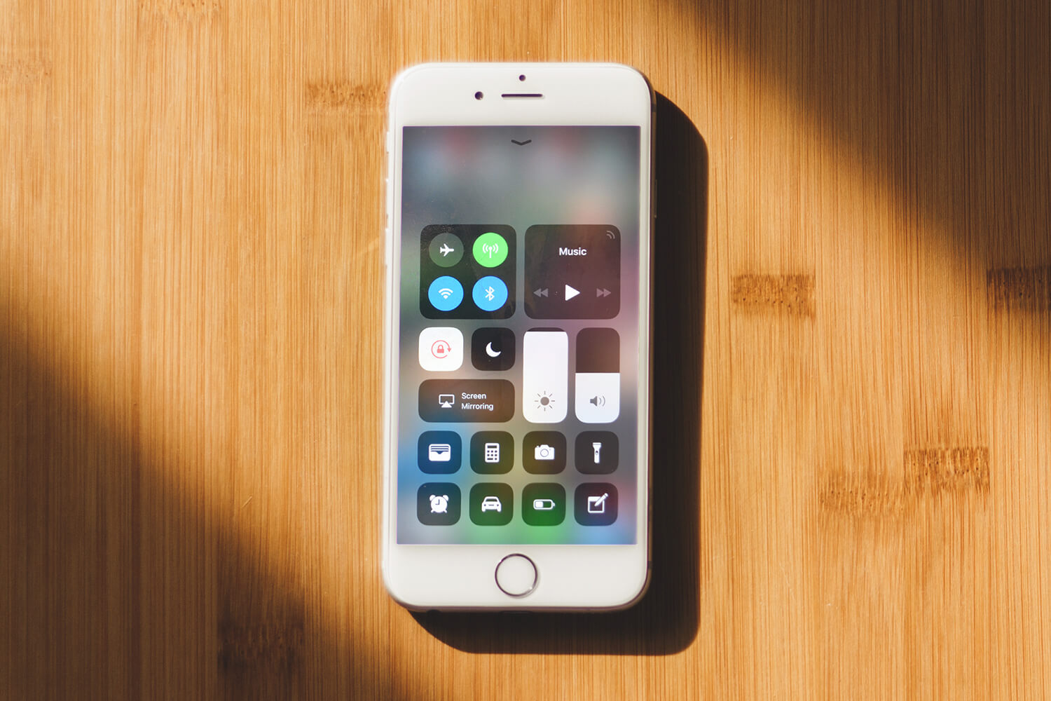 Iphone em uma mesa de madeira Saiba as diversas transformações do IOS ao longo do tempo!