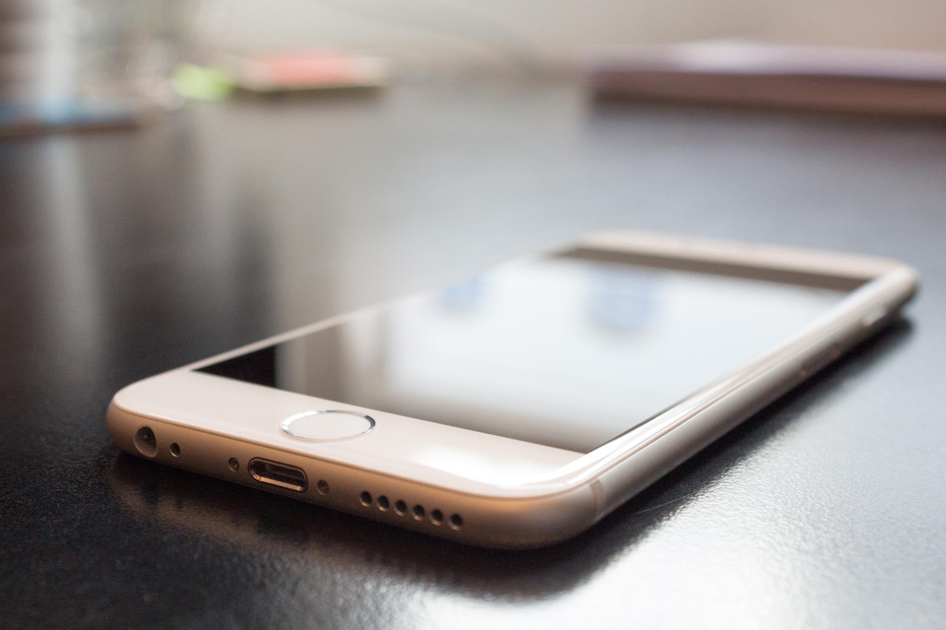 iPhone branco em uma mesa Se você tem iPhone, veja quais são os melhores apps para o seu aparelho!