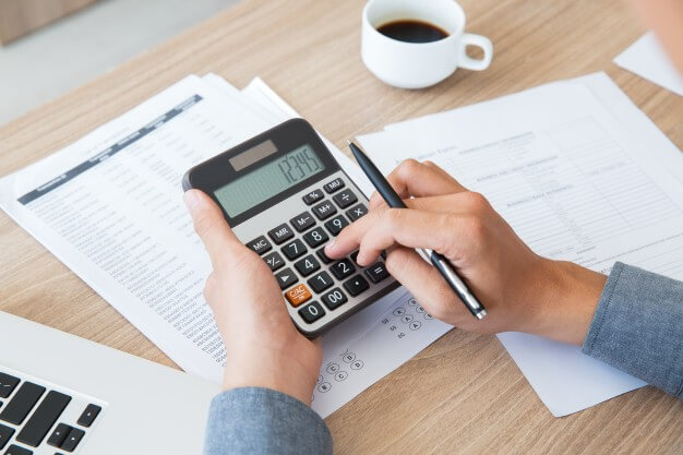 homem usando a calculadora calculando-imposto-de-renda