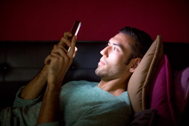 homem deitado mexendo no celular homem-vicio-em-celular