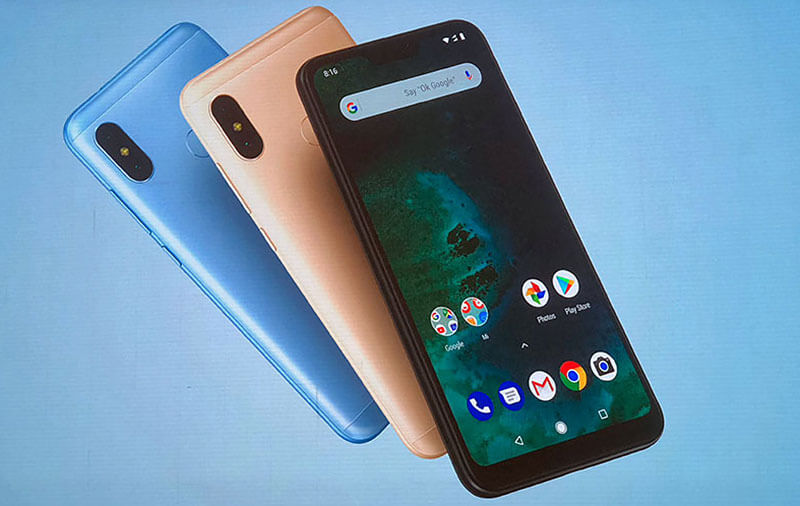 Xiaomi Mi A2 Lite Foto com 3 aparelhos Xiaomi Mi A2 Lite sobre um fundo azul. O aparelho que aparece em maior destaque está de frente, tem a cor preta e está com a tela ligada, enquanto os outros dois estão dispostos com a parte traseira para cima, atrás do primeiro aparelho, nas cores rose gold e azul, respectivamente.