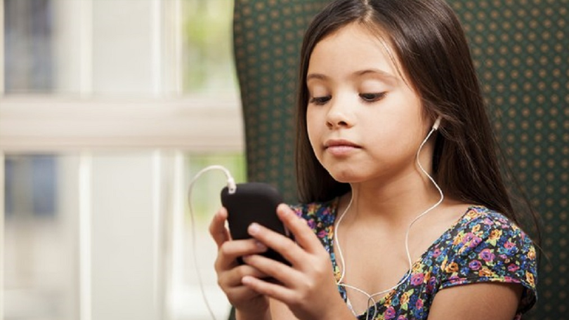criança com celular ouvindo música