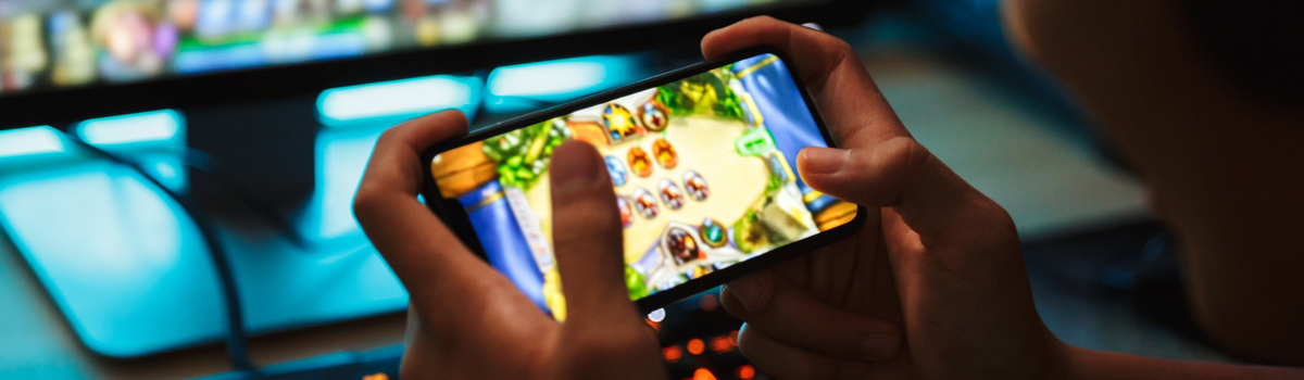 Mãos segurando um smartphone gamer, com o visor mostrando o jogo.