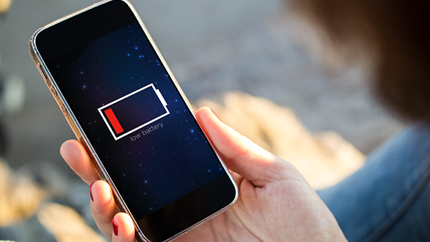 Na imagem, um celular exibindo na tela um símbolo de nível de bateria baixa